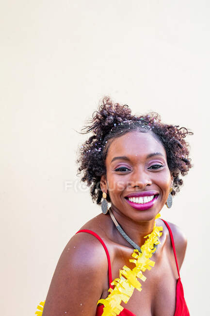 Emocionada mujer afroamericana de pie bajo la caída de confeti en caso de fondo blanco - foto de stock
