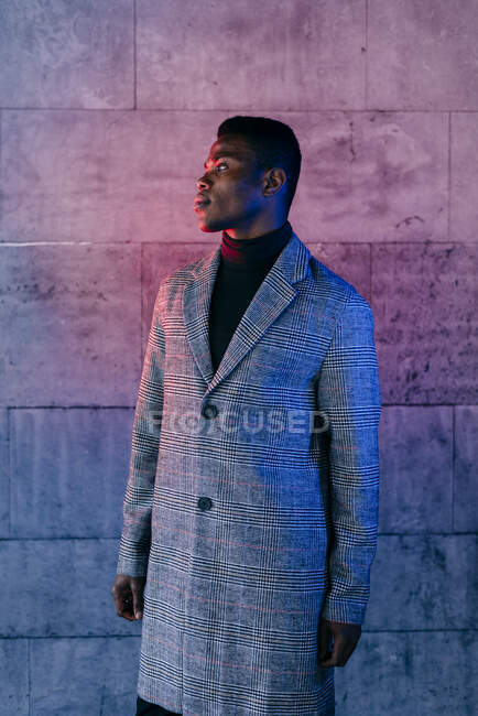 Portrait of elegant black man with grey coat standing in the street — Stock Photo
