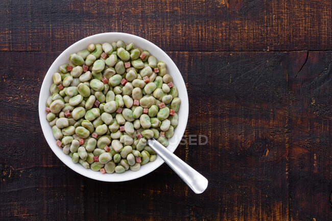 Top view of frozen broad beans in bowl served on rustic wooden table — Stock Photo