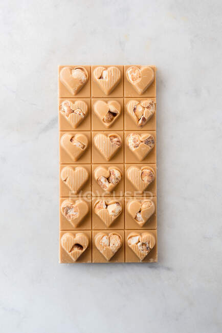 Draufsicht auf köstliche Bonbons mit Nüssen in Herzform auf Marmortischhintergrund — Stockfoto