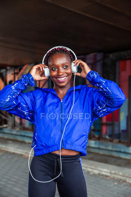 Desportista alegre ouvindo música — Fotografia de Stock