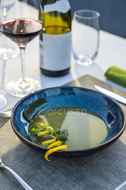 Delicious and well garnished lentil soup paired with red wine at outdoor high cuisine restaurant — Stock Photo
