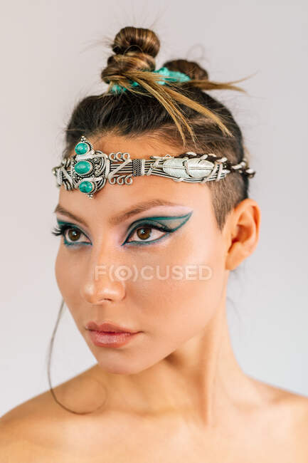 Bella giovane modello femminile con trucco stile orientale ed elegante ornamento d'argento con pietre verdi sulla testa — Foto stock