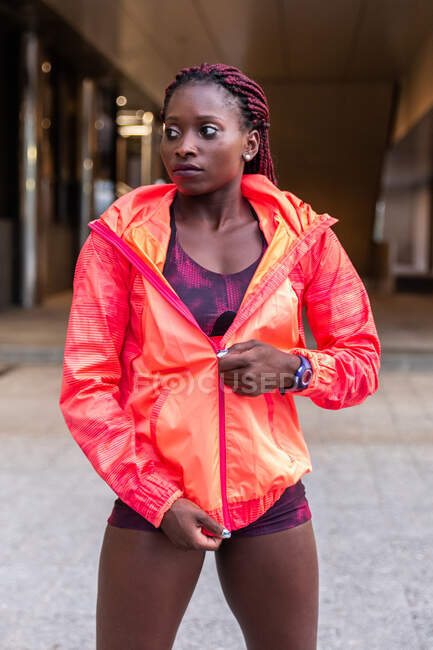 Femme musculaire zippant veste rouge — Photo de stock