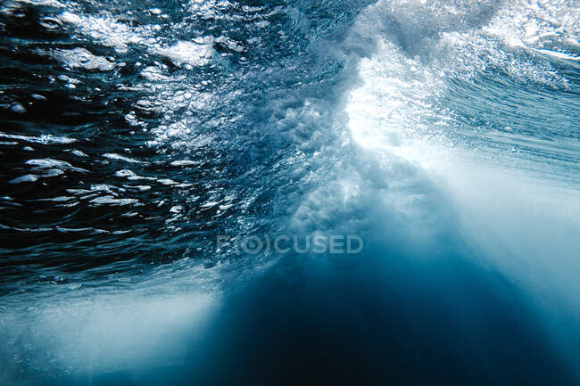 Vista subacquea del fondo roccioso grezzo del mare con acqua blu durante il giorno — Foto stock