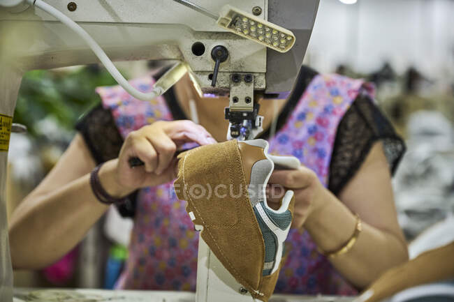 Dettaglio delle mani del lavoratore che cuce nella pelle delle scarpe alla fabbrica di scarpe cinese — Foto stock