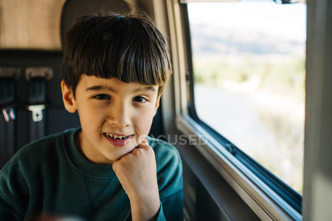 Маленький мальчик сидит в доме на колёсах и смотрит в камеру. — стоковое фото