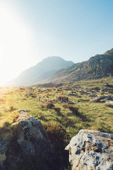 Paysage spectaculaire de vertes collines rocheuses dans les hautes terres par une journée ensoleillée sous un ciel bleu sans nuages au Pays de Galles — Photo de stock