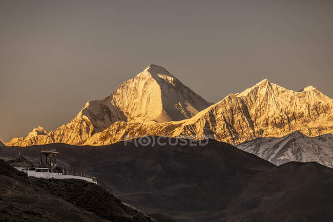 Cenário espetacular do cume da montanha Dhaulagiri iluminado pela luz solar laranja à noite no Nepal — Fotografia de Stock