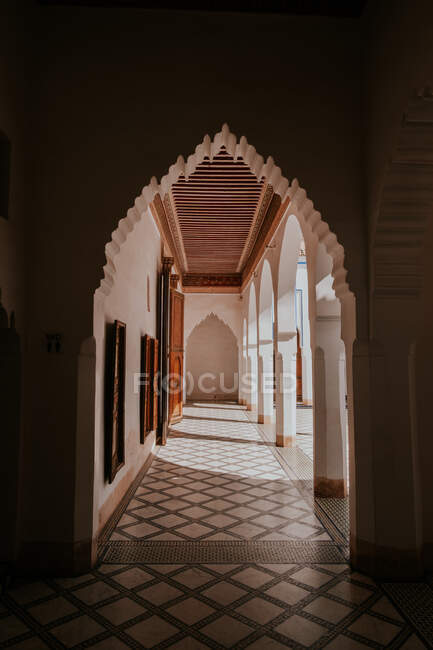 Arco ornamental con suelo de baldosas de mármol dentro del palacio islámico tradicional en Marrakech, Marruecos - foto de stock