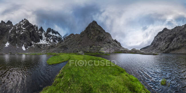 Espectacular paisaje de montañas cubiertas de nieve al atardecer reflejado en un lago - foto de stock