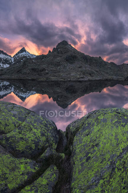 Paysage spectaculaire de montagnes enneigées au coucher du soleil réfléchies sur un lac — Photo de stock
