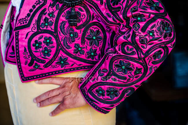 Crop unrecognizable male toreador in traditional costume decorated with embroidery preparing for corrida festival — Stock Photo