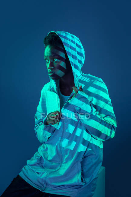 Black woman with sporty outfit in the studio illuminated with gels and projector lights — Stock Photo