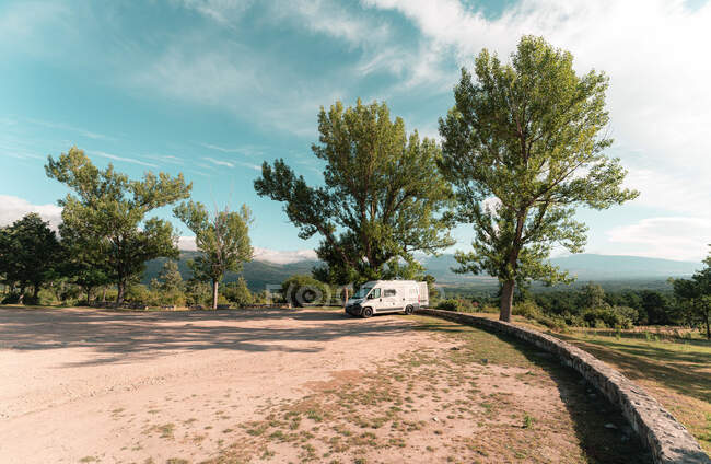 Viajando campista estacionado na estrada de asfalto em bosques no dia ensolarado no verão — Fotografia de Stock
