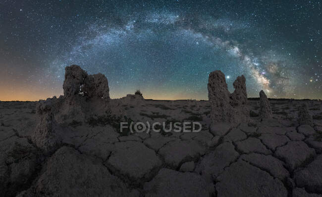 Magnífica paisagem com brilhante Via Láctea à noite céu estrelado sobre terreno árido deserto árido com formações rochosas — Fotografia de Stock