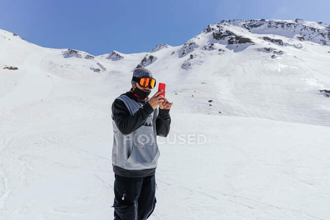 Unrecognizable male athlete in sports glasses taking photo of Sierra Nevada on cellphone in province of Granada Spain — Stock Photo