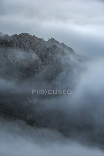 Ruhige Landschaft mit nebelverhangenem Gebirge vor bewölktem Morgenhimmel im Guadarrama-Nationalpark in Madrid, Spanien — Stockfoto