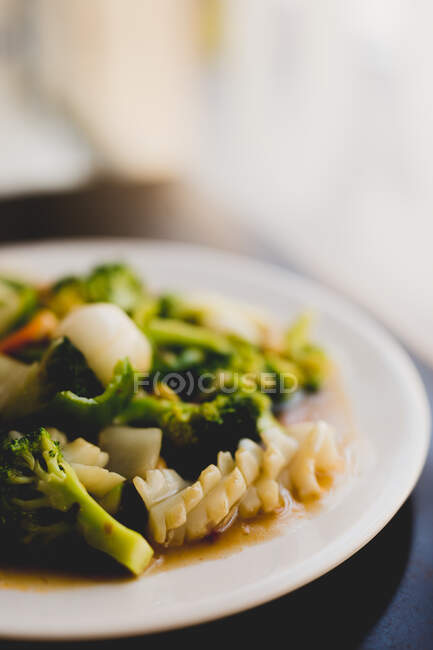 White ceramic plate with broccoli and squid meal — Stock Photo