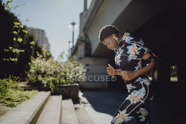Young fitness African American woman running while on city street — Stock Photo