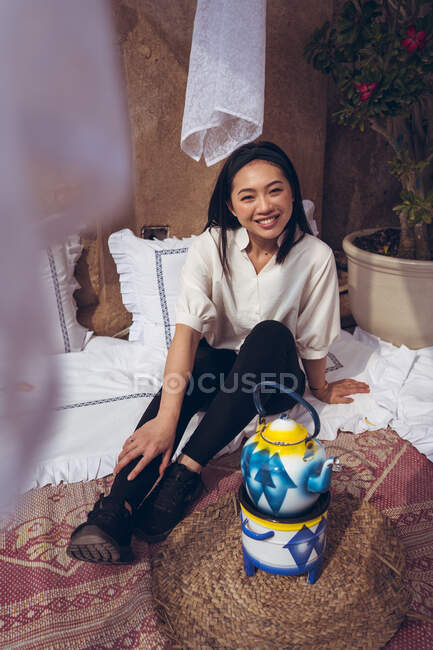 Ritratto di donna asiatica che si rilassa accanto a un bollitore sul pavimento. Negozio di tè nel quartiere storico Al Fahidi — Foto stock