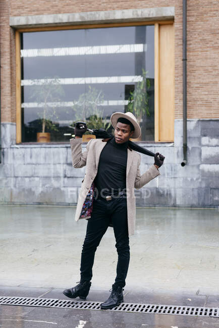Retrato de hombre negro elegante con abrigo y paraguas en la calle — cuerpo completo, joven - Stock Photo | #517131634