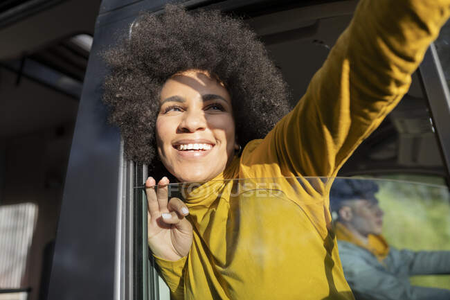 Aufgeregte afroamerikanische Reisende lächelt und macht Selfie, während sie aus dem Fenster des Lieferwagens neben ihrem Freund guckt — Stockfoto