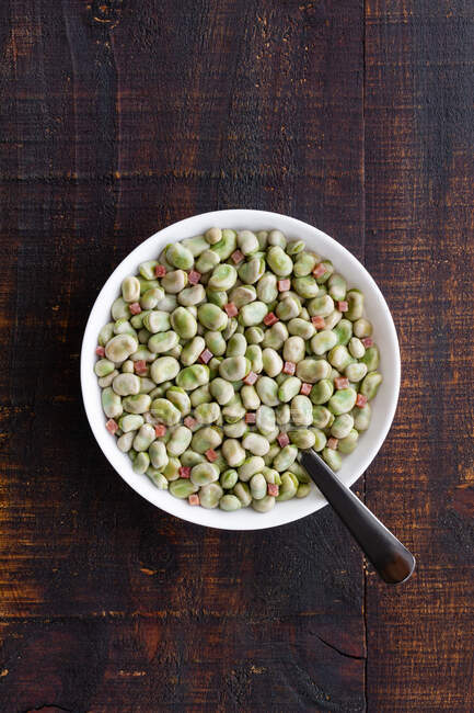Top view of frozen broad beans in bowl served on rustic wooden table — Stock Photo