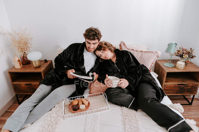 Hohe Winkel der sanften Paar entspannen auf dem Bett zusammen beim Frühstück in der Früh — Stockfoto