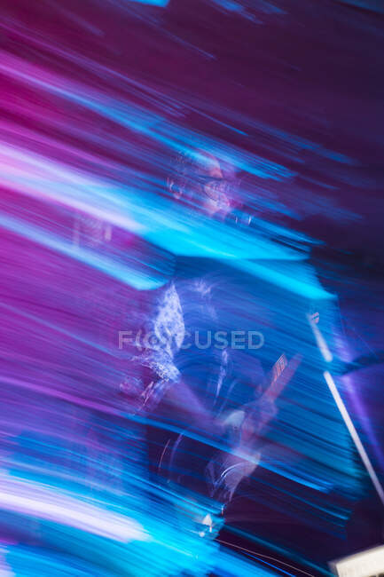 Escena borrosa del guitarrista tocando una guitarra eléctrica con escenario - foto de stock
