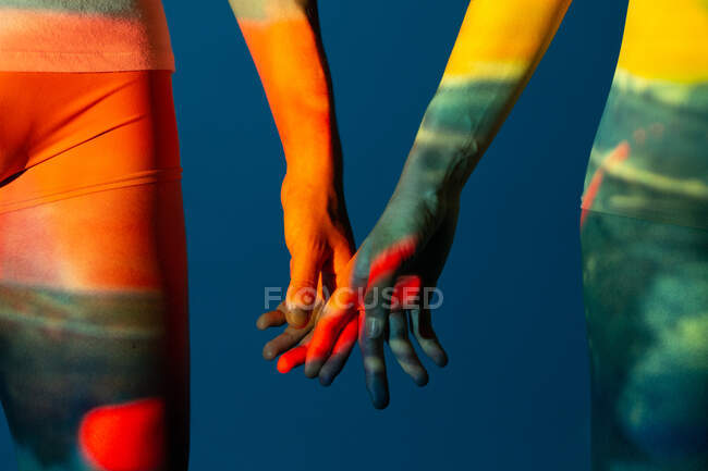 Artistic image of couple hands showing love under projector lights — Stock Photo