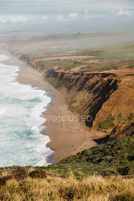 Изумительный пейзаж национального побережья Пойнт-Рейес с пенными океанскими волнами, бегущими по пляжу с бесконечными огромными скалами в Калифорнии — стоковое фото