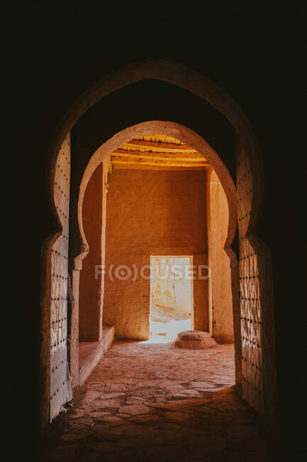 Passaggio ad arco scuro dell'antico edificio arabo nella giornata di sole a Marrakech, Marocco — Foto stock