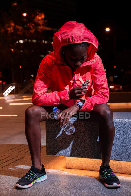 Esportista étnica fazendo lanche na rua — Fotografia de Stock