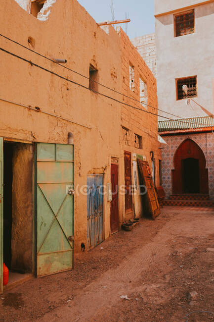 Edifício islâmico desgastado com porta de garagem aberta localizada na antiga rua de Marraquexe, Marrocos — Fotografia de Stock
