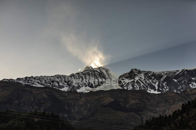 Increíble paisaje de haz de luz solar brillante iluminando pico de montaña en Himalaya en invierno en Nepal - foto de stock