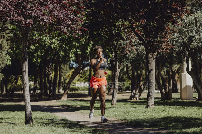 Junge Fitness-Afroamerikanerin läuft und turnt im Park — Stockfoto