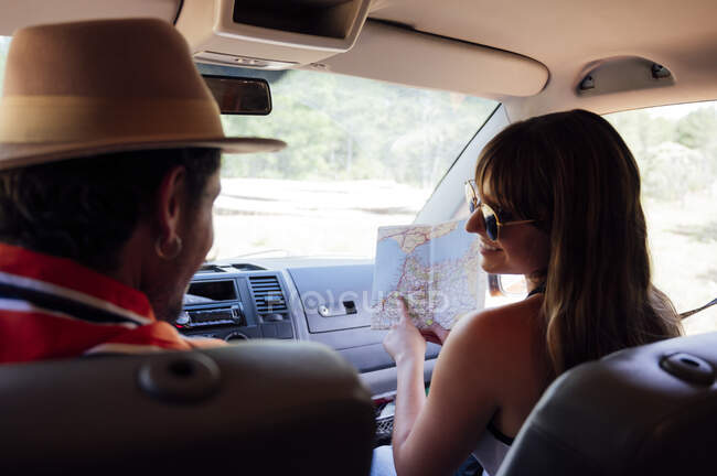Back view of anonymous couple of travelers riding van and enjoying road trip in summer — Stock Photo