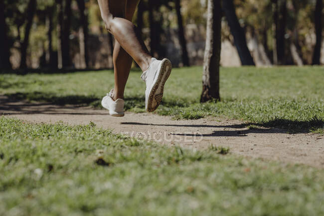 Crop legs of African American woman running and making exercise on park — Stock Photo