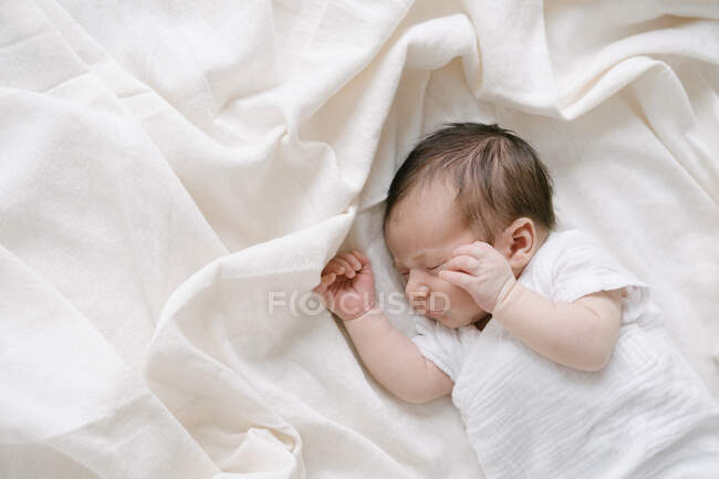 Vue du dessus du bébé doux couché sur un lit doux et dormant à la maison — Photo de stock