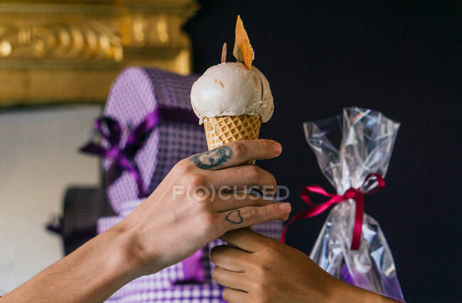 Crop unrecognizable male buying sweet ice cream in waffle cone in candy shop — Stock Photo