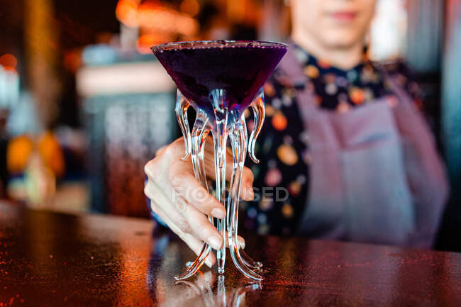 Anonyme Barkeeperin steht an der Theke mit einer Art alkoholischem Getränk, das in kreativen Cocktailgläsern in Quallenform serviert wird — Stockfoto