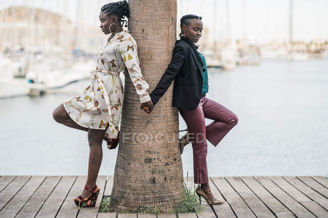 Moda senhoras afro-americanas na moda passar o tempo juntos e apertando as mãos juntos no parque em dia brilhante — Fotografia de Stock