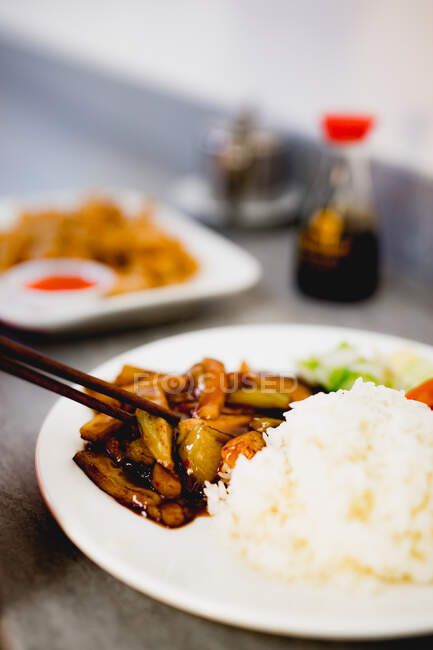 Appetizing cooked Yuxiang eggplant with healthy vegetables and rice on white plate in Asian restaurant — Stock Photo