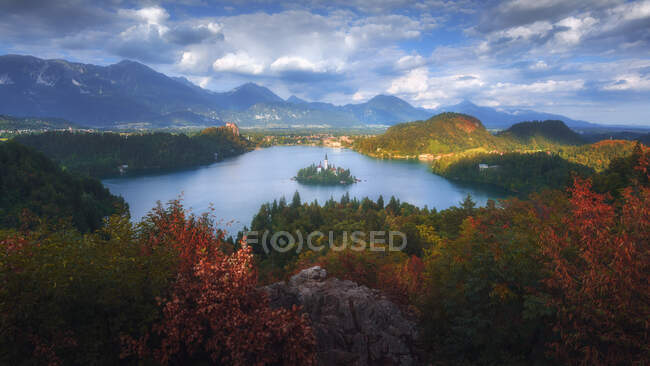 Spettacolare scenario di laghetto calmo con isola e castello situato in altopiani rocciosi in Slovenia — Foto stock