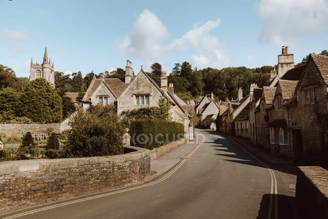 Route asphaltée au milieu de chalets vieillis par temps nuageux dans le village au Royaume-Uni — Photo de stock