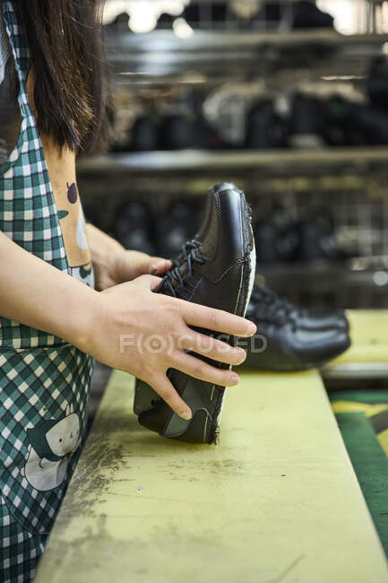 Detail of woman's hands while checking the shoes in quality control production line in Chinese shoes factory — Stock Photo