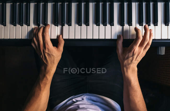 Homme anonyme jouant du piano à la maison — Photo de stock