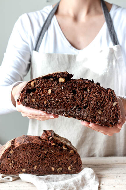 Crop faceless woman hands holding freshly baked sourdough rye bread Crumb pan cutting in half — Stock Photo