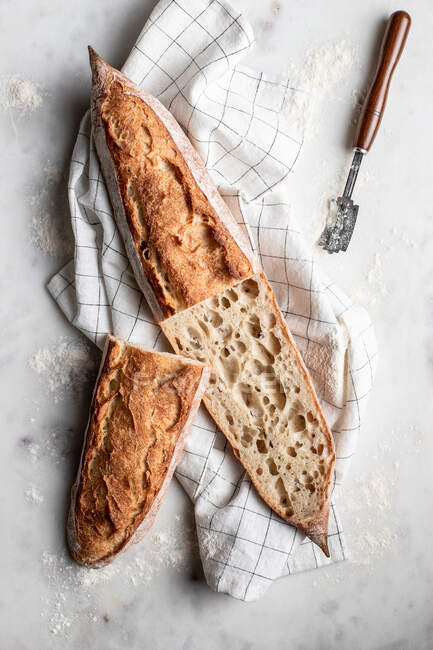 Vista superior de delicioso pão caseiro colocado em pano na mesa de mármore — Fotografia de Stock